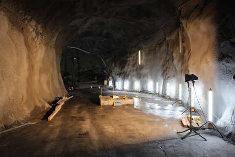 Die beschädigten Batterien stehen in der Mitte des Tunnels am Boden und werden von einem Licht beleuchtet.